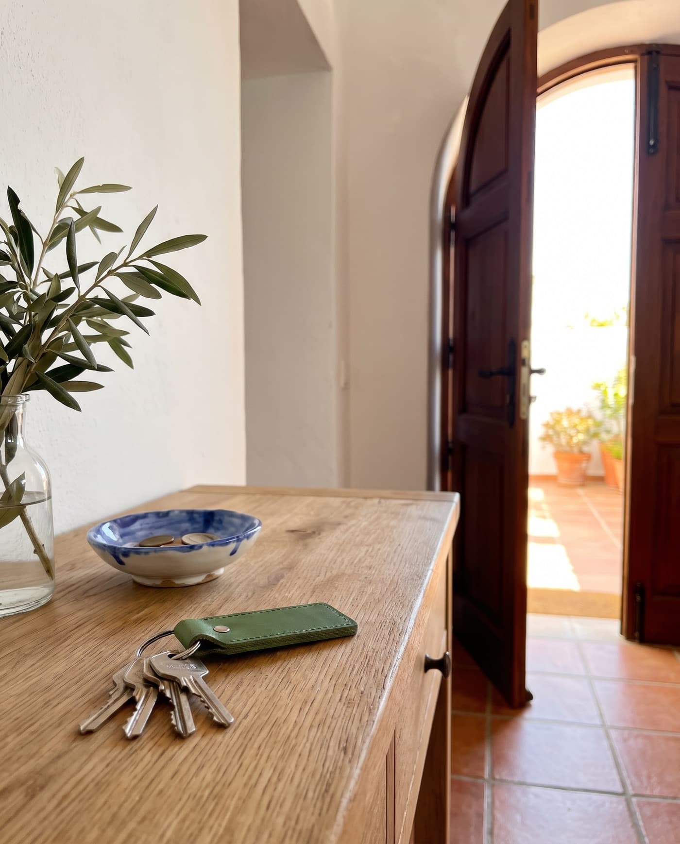 Llaves sobre un mueble de madera junto a una puerta abierta